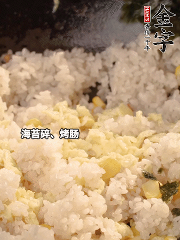 剩米飯下鍋炒散，依次下玉米粒、雞蛋、烤腸、海苔碎翻炒均勻。