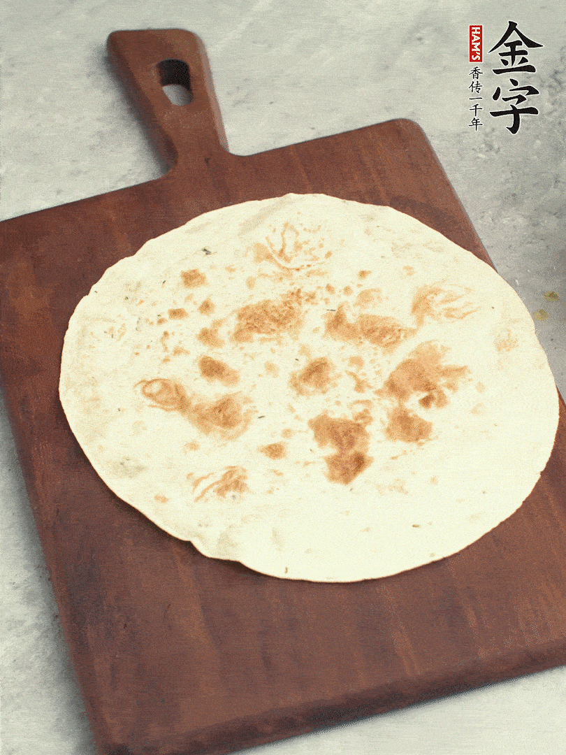 食材依次鋪在卷餅皮上，卷起來。