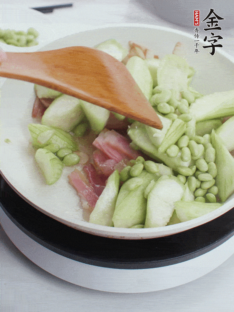 依次下絲瓜、青豆翻炒，炒至絲瓜打蔫縮小。