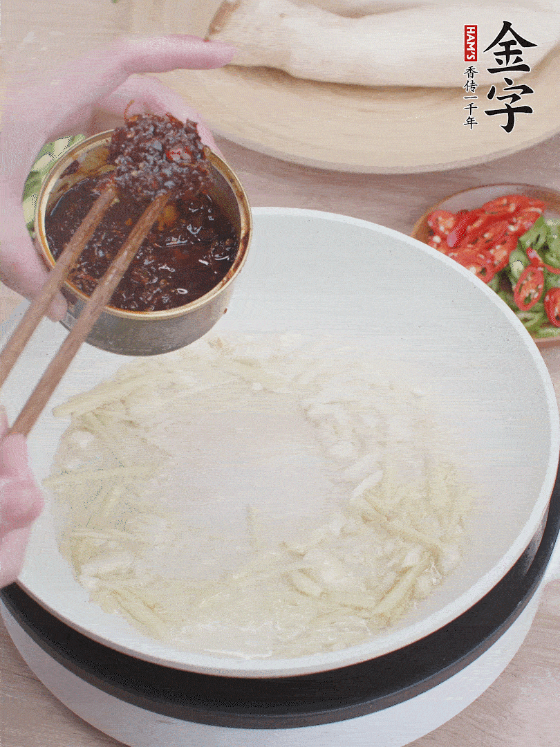 起鍋熱油，姜蒜、金字火腿干貝醬煸香。