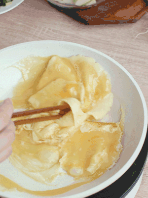 油6成熱時(shí)，下雞蛋液，邊緣凝固時(shí)翻拌成塊狀。
