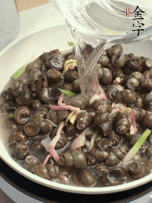 倒處理干凈的螺螄翻炒，加3勺料酒。加清水蓋過螺螄，中火蓋蓋煮5分鐘。