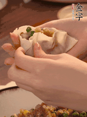 取一大勺餡料放進餃子皮里，用大拇指按住頂部餡料，再用虎口掐出形狀。