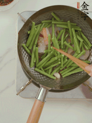 下掰好的缸豆段翻炒，略燜煮。