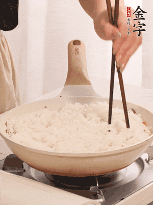 把瀝干水分的米飯均勻鋪在上面，筷子戳幾個洞，以便透氣，轉(zhuǎn)小火蓋上蓋子燜至水分收干，大概10分鐘。