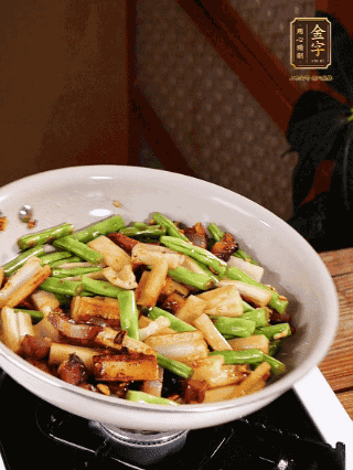油熱下蒜末、干辣椒、醬肉煸炒出香味，依次下藕條、豆角翻炒均勻